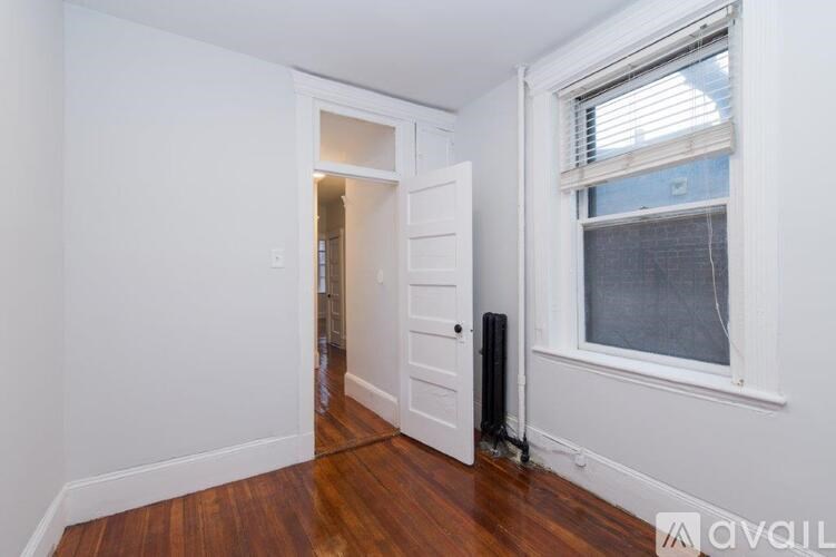 A room with a white door and a window with blinds.