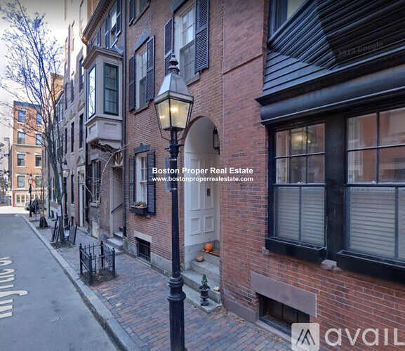 A street view of a building with a sign for Boston Proper Real Estate.