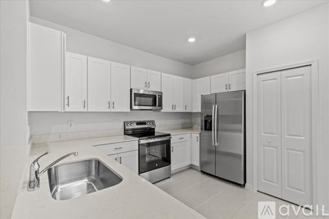 A kitchen with white cabinets and stainless steel appliances.