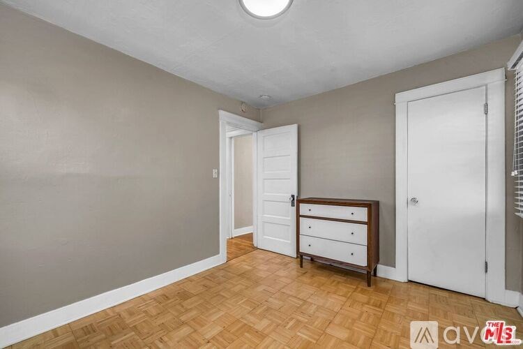 A room with a wooden floor and a white door.