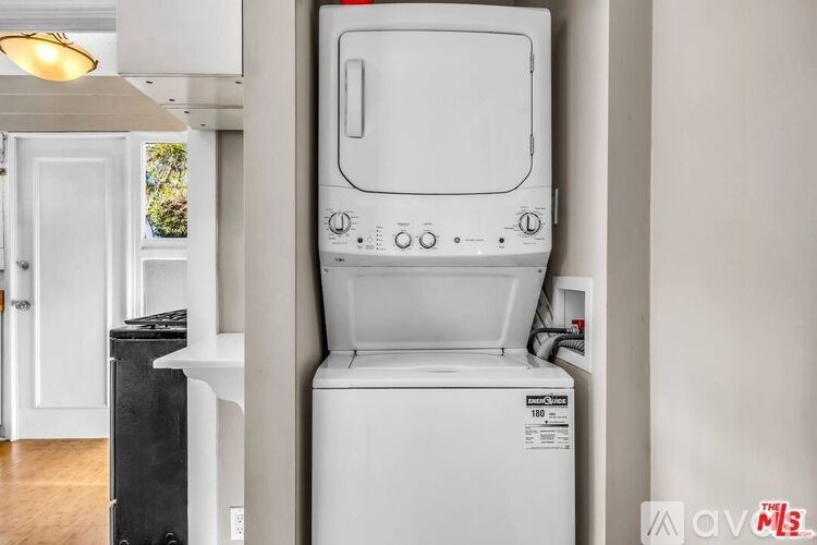 A white washing machine is in a kitchen.