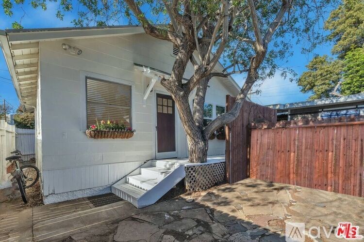 A white house with a tree in front of it.