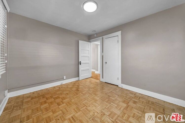 A room with wooden flooring and a white door.