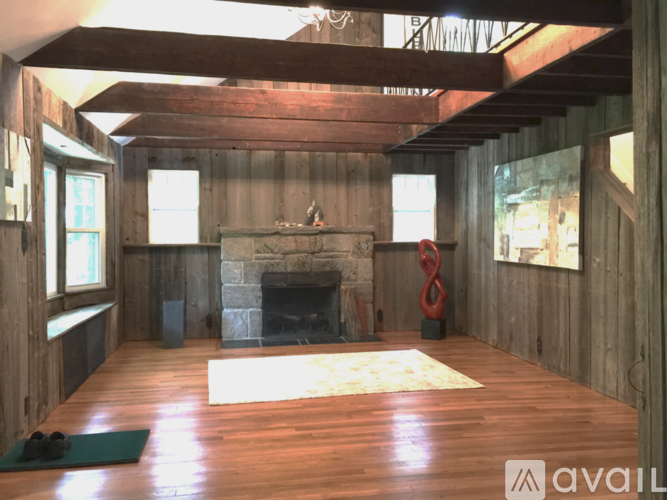 A room with wooden walls and a stone fireplace.