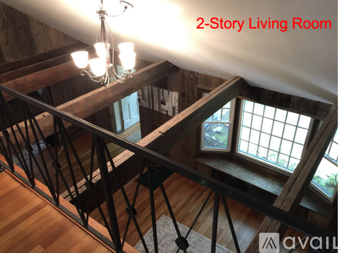 A living room with a staircase and a chandelier.