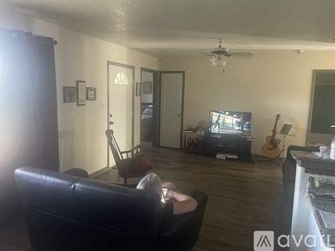 A living room with a black leather couch and a television.