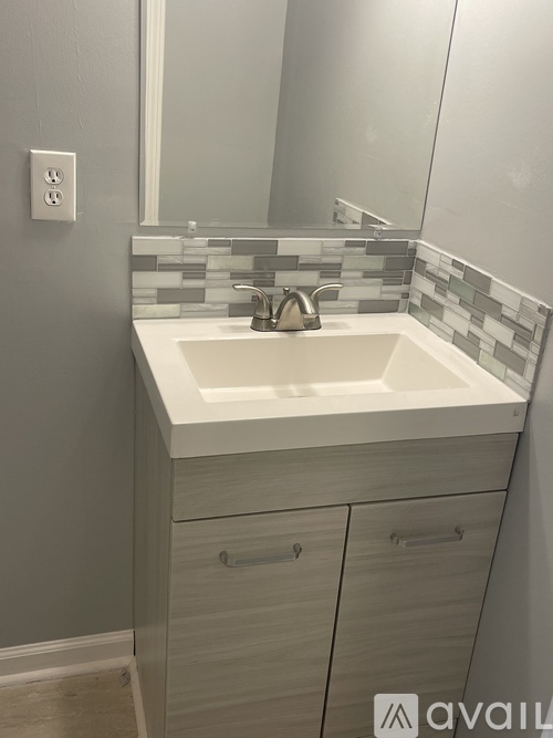 A bathroom sink with a mirror above it and a cabinet below.