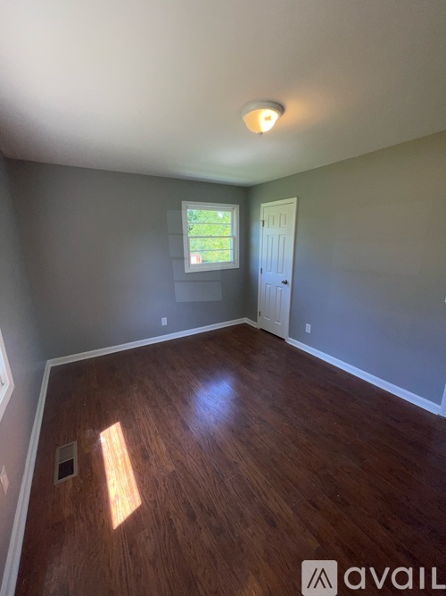 A room with wooden flooring and a window.