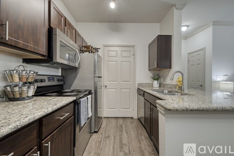 A kitchen with dark wood cabinets and a white door.