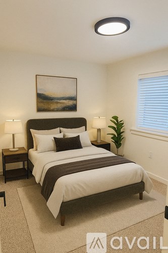 A bedroom with a large bed and a painting on the wall.