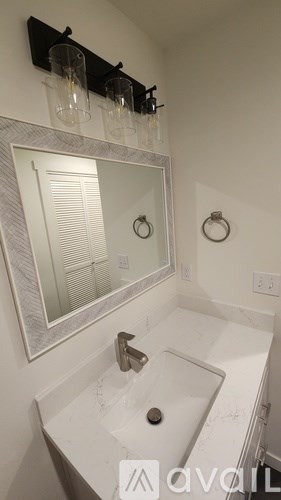A kitchen with white cabinets and a black door.