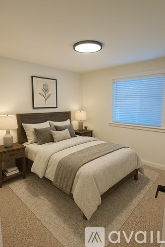 A bedroom with a bed, nightstand, and window.