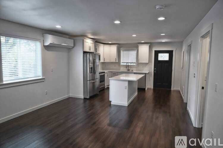 A kitchen with white appliances and a white island in the middle of the room.