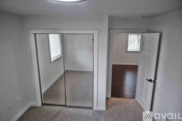 A room with a carpeted floor and a door leading to another room.