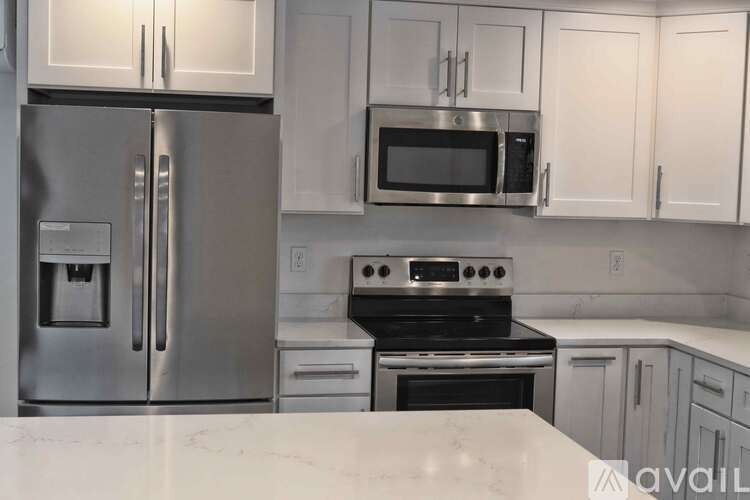 A kitchen with a stainless steel refrigerator, microwave, and oven.