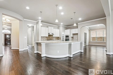 A spacious kitchen with white cabinets and a central island.