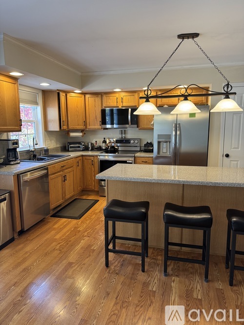 A kitchen with wooden cabinets and a stainless steel refrigerator.