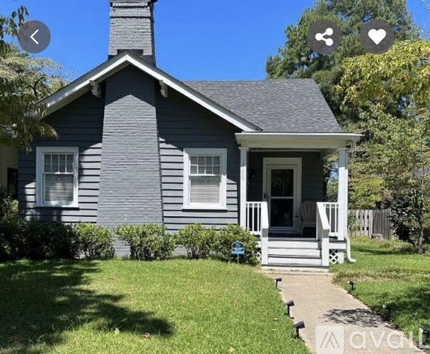 A small house with a grey exterior and a white porch.