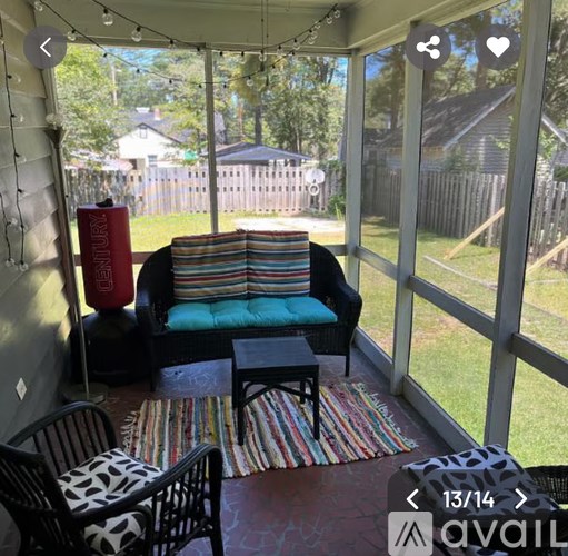 A sunny patio with a striped couch and a small table.