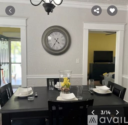 A dining room with a black table set for two.