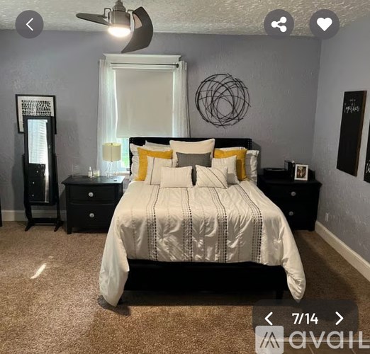 A bedroom with a large bed and a ceiling fan.