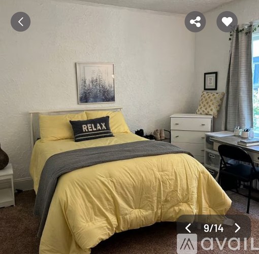 A bedroom with a yellow bedspread and a grey blanket.