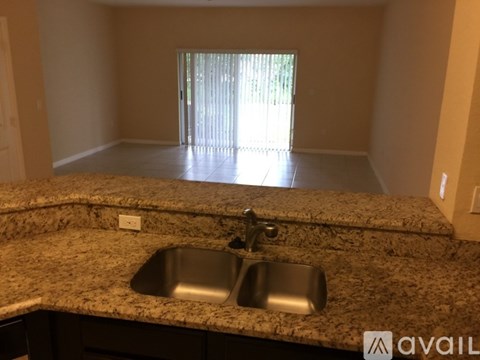 A kitchen counter with a sink and a window in the background.