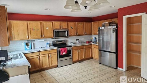 A kitchen with wooden cabinets and a refrigerator.
