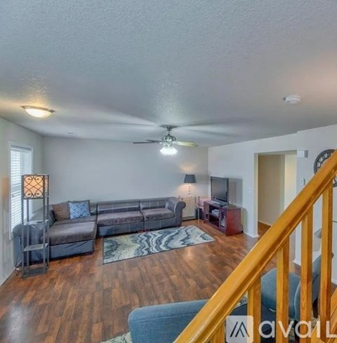 A living room with a grey couch and a wooden floor.