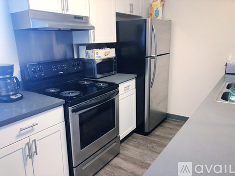 A kitchen with a black stove top oven, a white oven, and a black refrigerator.