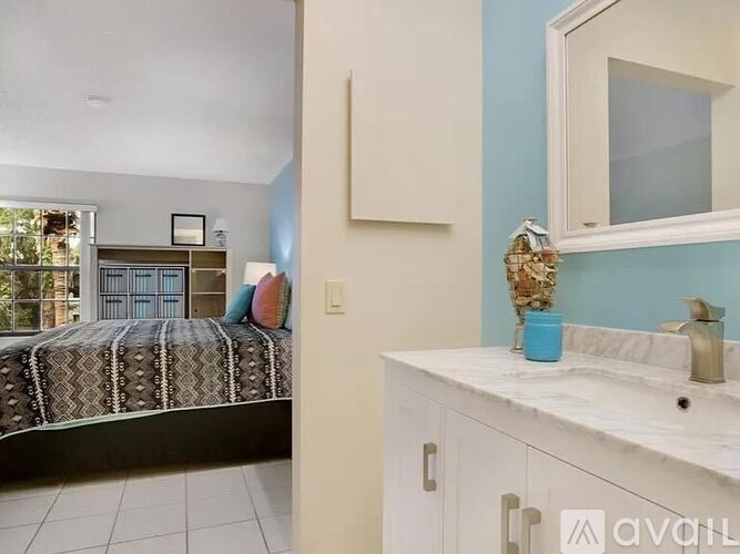 A bedroom with a bed, a mirror, and a cabinet.