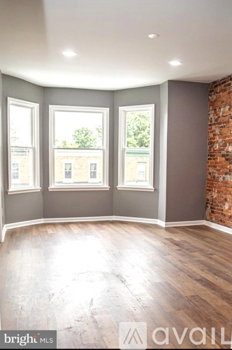 A room with a brick wall and wooden flooring.
