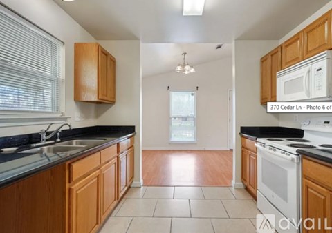 A kitchen with wooden cabinets and black countertops.