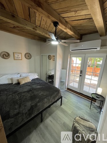 A bedroom with a bed, a chair, and a ceiling fan.