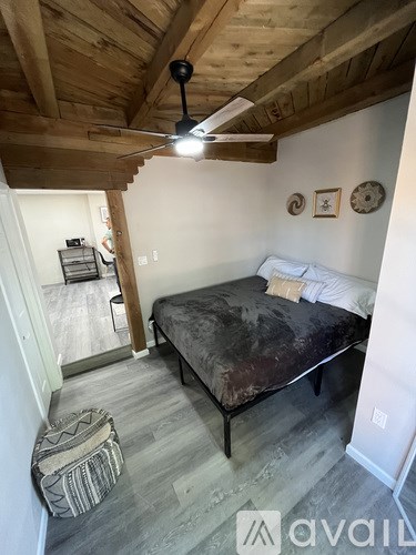 A bedroom with a bed, a ceiling fan, and a rug.