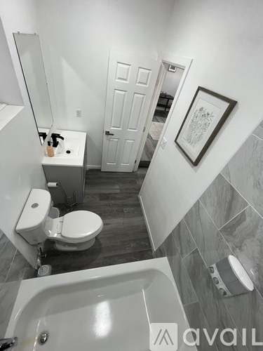 A bathroom with a toilet, sink, and bathtub.