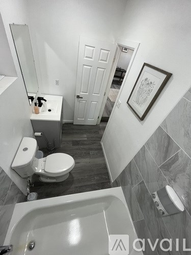 A bathroom with a toilet, sink, and bathtub.