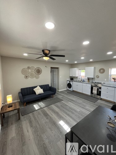 A living room with a blue couch and a ceiling fan.