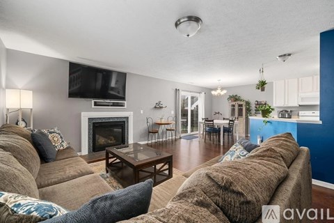 A living room with a fireplace and a television mounted on the wall.
