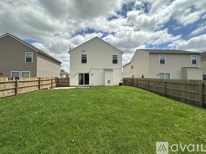 A row of houses with a grassy yard in the foreground.