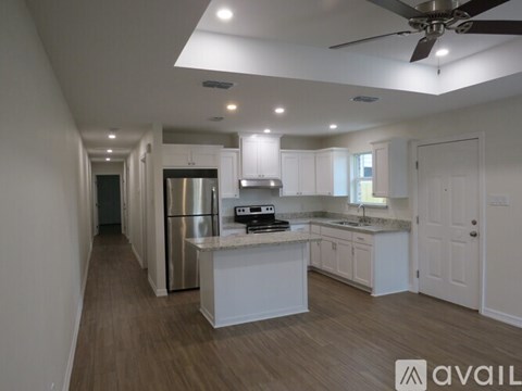 A modern kitchen with a refrigerator, sink, and cabinets.
