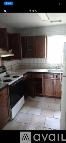 A kitchen with brown cabinets and a black oven.