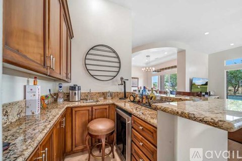 A kitchen with wooden cabinets and a marble countertop.