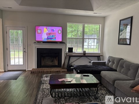 A living room with a fireplace and a television playing a cartoon.