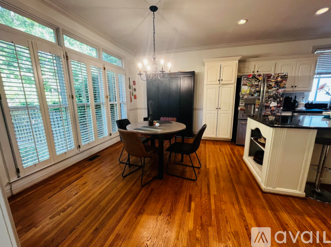 A dining area with a table and chairs in the middle of the room.