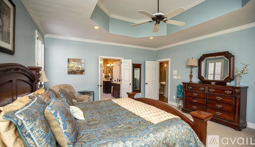 A bedroom with a large bed and a dresser.