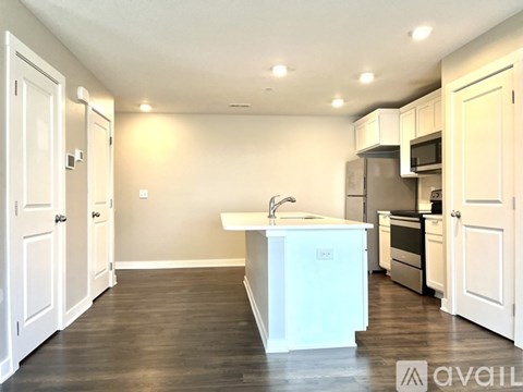 A kitchen with white cabinets and a white island in the middle.