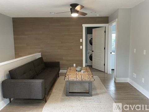 A living room with a grey couch and a wooden coffee table.