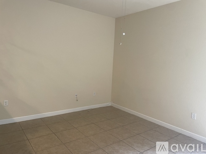 Empty room with beige tiled floor and white walls.