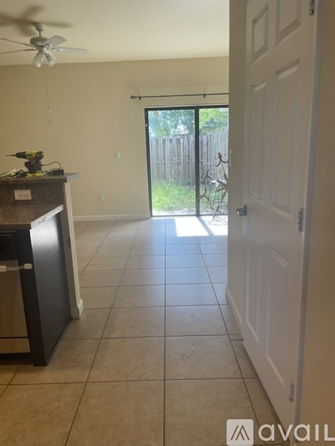 A kitchen with a fan and a counter with a sink.